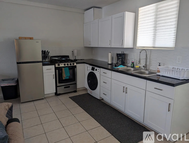 A kitchen with white cabinets and appliances.