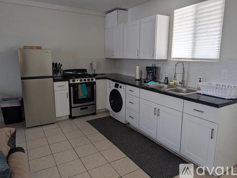 A kitchen with white cabinets and appliances.