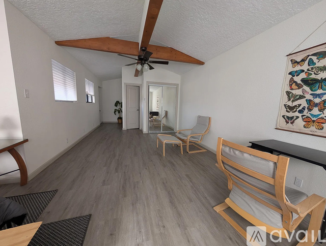 A living room with a ceiling fan and a painting on the wall.