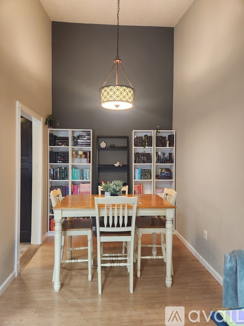 A dining room with a wooden table and chairs.