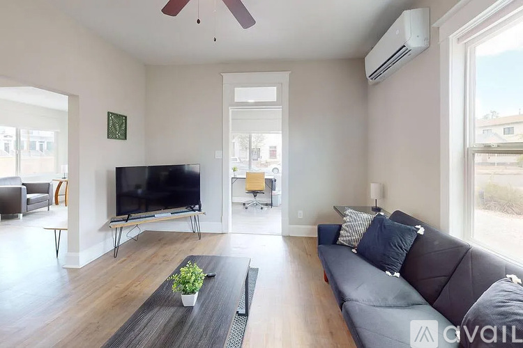 A living room with a grey couch and a flat screen TV.