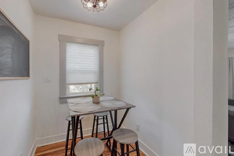 A small dining room with a round table and four chairs.