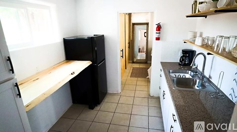 A kitchen with black appliances and a wooden bench.