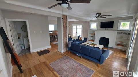 A living room with a blue couch and a fireplace.