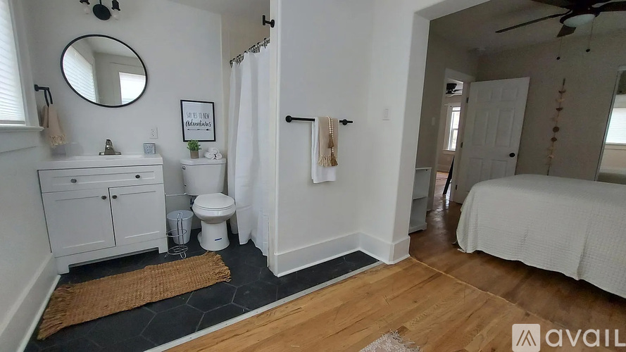 A bathroom with a toilet, sink, and mirror.