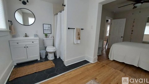 A bathroom with a toilet, sink, and mirror.