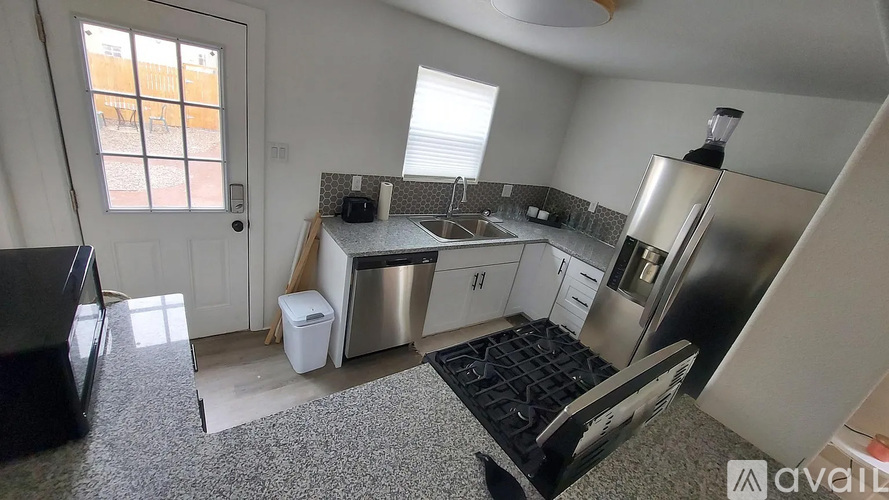 A kitchen with a refrigerator, sink, and microwave.