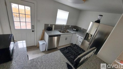 A kitchen with a refrigerator, sink, and microwave.