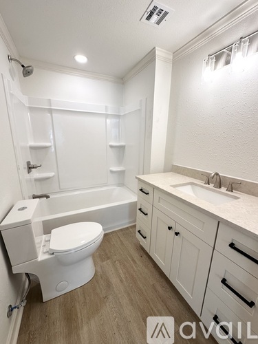 A white bathroom with a toilet, sink, and bathtub.