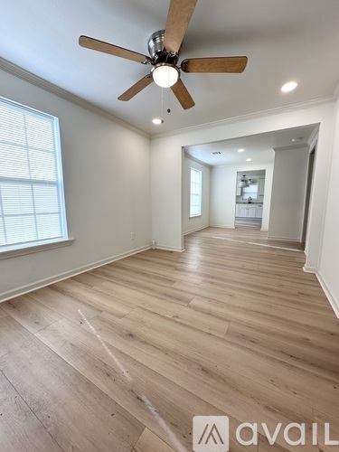 A room with a ceiling fan and wooden flooring.