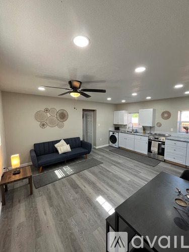 A living room with a blue couch and a kitchen in the background.