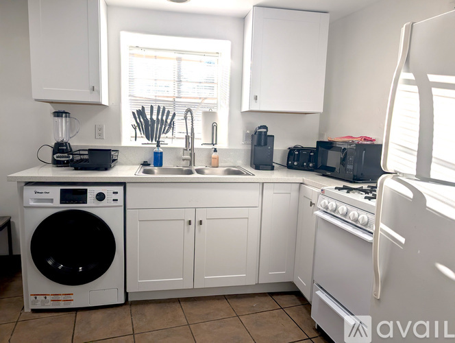 A kitchen with white appliances and cabinets.