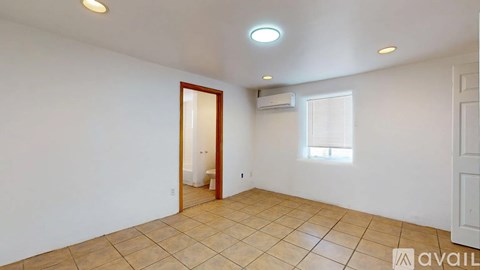 A room with a tiled floor and a door leading to another room.