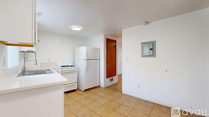 A kitchen with white cabinets and a white counter top.
