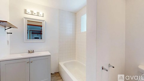 A white bathroom with a tub, sink, and medicine cabinet.