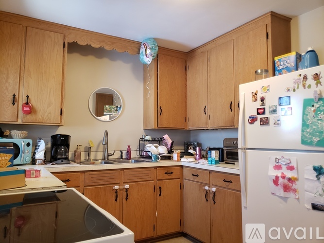 A kitchen with wooden cabinets and a white fridge.