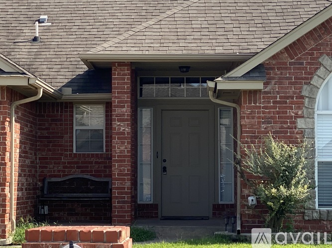 A brick house with a grey door and a small window above it.