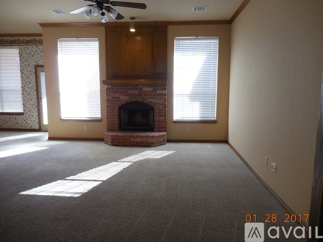 A living room with a fireplace and a ceiling fan.