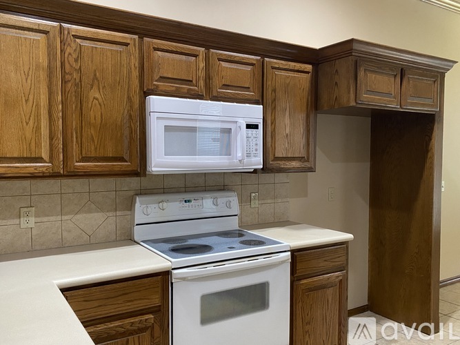 A kitchen with a white stove and microwave above a white counter.