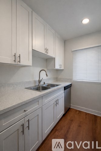 A kitchen with white cabinets and a sink.