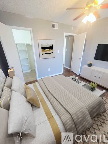 A living room with a striped couch and a ceiling fan.