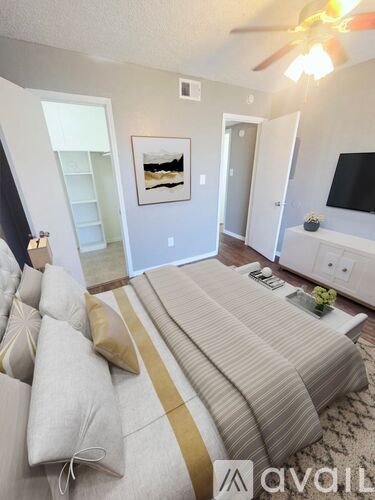 A living room with a striped couch and a ceiling fan.