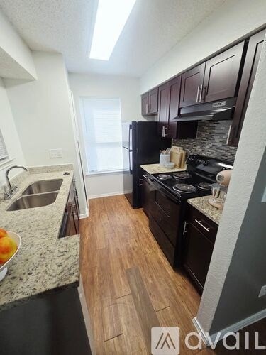 A kitchen with black cabinets and a stove top oven.