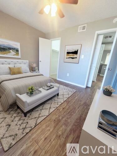 A bedroom with a large bed and a bench in the middle of the room.