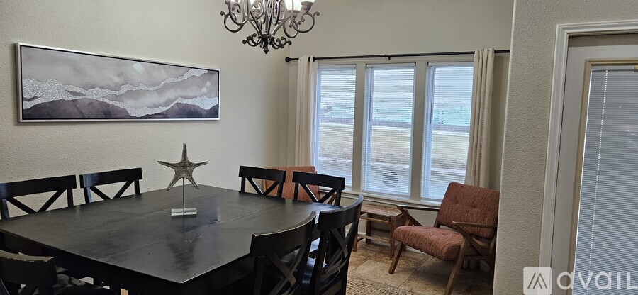 A dining room with a large table and chairs.