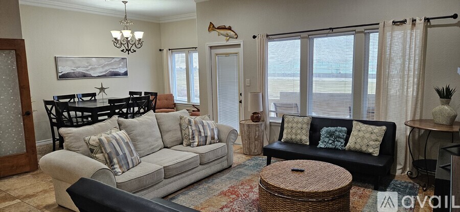 A living room with a grey couch and a black ottoman.