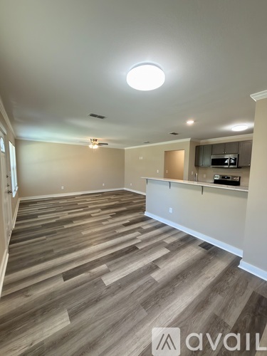 A living room with a wood floor and a television.
