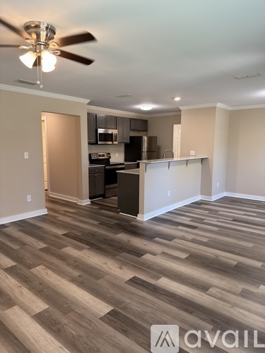 A room with a ceiling fan and wooden flooring.