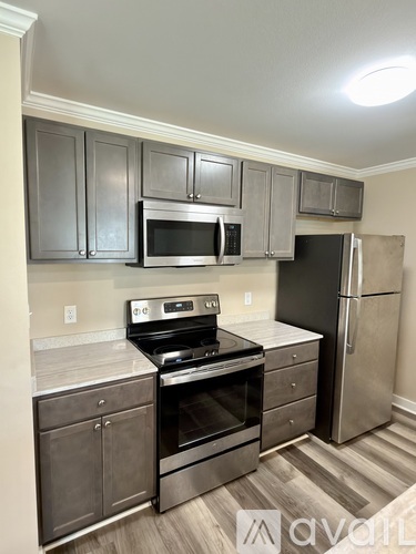 A kitchen with stainless steel appliances and cabinets.