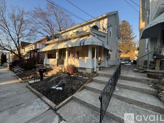 A house with a front yard and steps leading to the front door.
