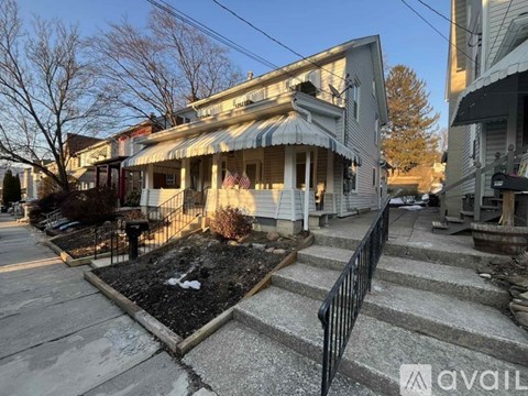 A house with a front yard and steps leading to the front door.