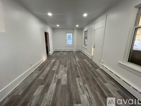 A room with wooden flooring and white walls.
