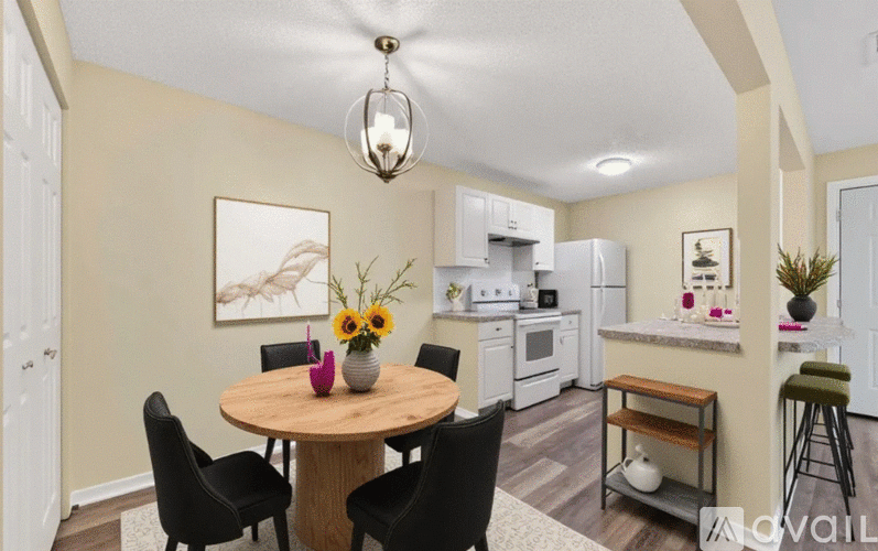 A dining room with a round table and chairs.