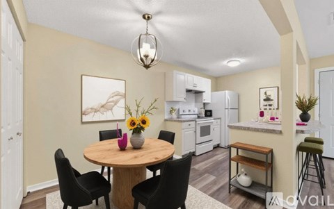 A dining room with a round table and chairs.