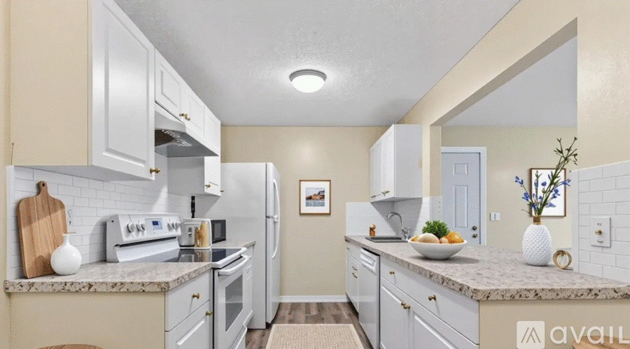 A kitchen with white appliances and cabinets.