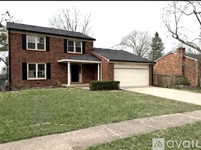 A brick house with a white garage door and a driveway.