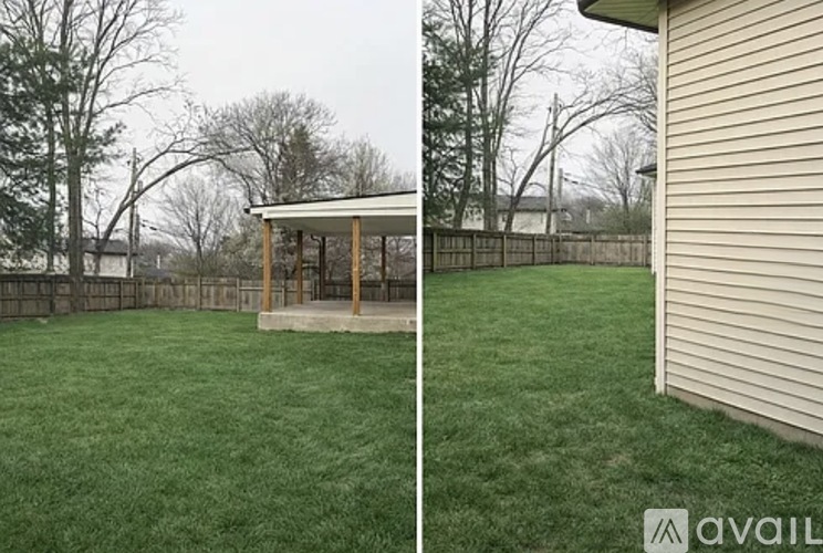 A backyard with a wooden structure and a fence.