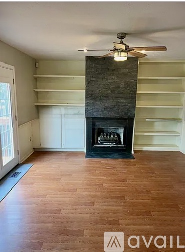 A room with a fireplace and a ceiling fan.