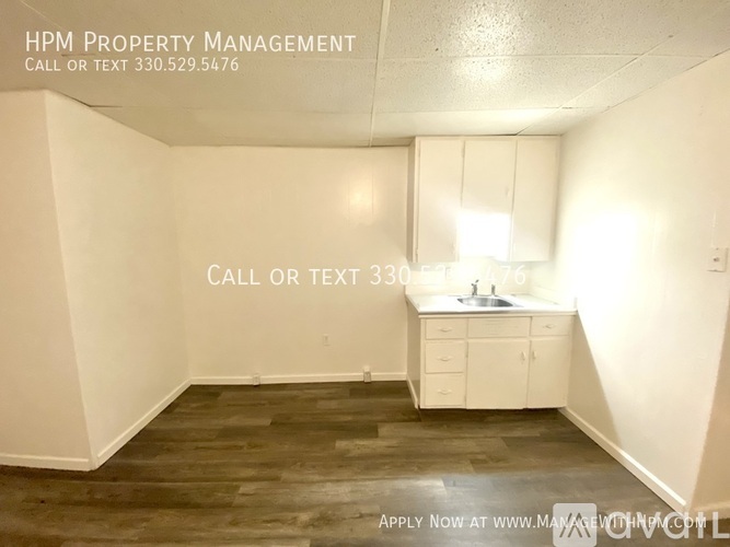 A room with a sink and cabinets is for rent.
