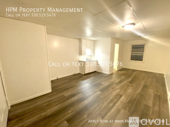 A room with wooden flooring and white walls, with text overlay for HPM Property Management.
