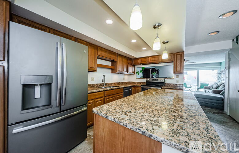 A modern kitchen with granite countertops and stainless steel appliances.
