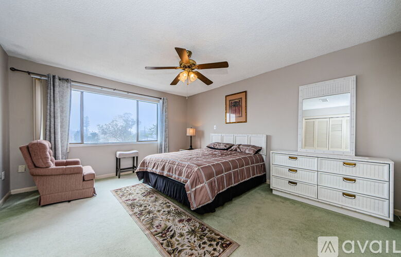 A bedroom with a bed, dresser, and chair.