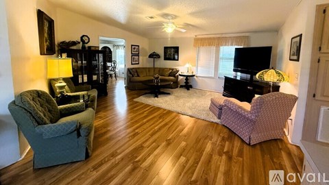 A living room with a green couch and a brown rug.