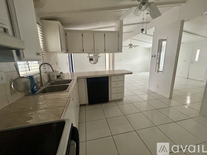 A kitchen with white cabinets and a black dishwasher.