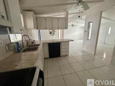 A kitchen with white cabinets and a black dishwasher.