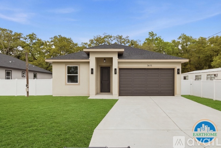 A two-story house with a garage door and a driveway.